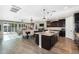 Open kitchen with island, dark cabinets, granite countertops, and breakfast bar at 24042 N 170Th Ln, Surprise, AZ 85387
