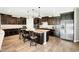 This spacious kitchen features dark wood cabinets, a large island with seating, and stainless steel appliances at 24042 N 170Th Ln, Surprise, AZ 85387