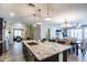 Open-concept kitchen with a large granite island and pendant lighting connects to the living and dining areas at 24042 N 170Th Ln, Surprise, AZ 85387