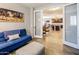 Comfortable living room featuring a blue sofa, ottoman, and view of the kitchen area through glass doors at 24042 N 170Th Ln, Surprise, AZ 85387