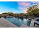 Outdoor pool with water features and lounge chairs surrounded by desert landscape at 24042 N 170Th Ln, Surprise, AZ 85387