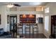 A stylish bar area featuring seating for three and unique display shelving with lighting at 2425 W Woburn Ln, Phoenix, AZ 85085