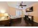 Comfortable bedroom featuring a ceiling fan, dark wood floors, and a window with plantation shutters at 2425 W Woburn Ln, Phoenix, AZ 85085