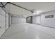 Spacious garage with epoxy flooring, built-in storage cabinets, and ample room for vehicles and storage at 2425 W Woburn Ln, Phoenix, AZ 85085