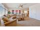 Inviting living room featuring a comfortable sectional sofa, ceiling fan, and beautiful wall art at 2425 W Woburn Ln, Phoenix, AZ 85085