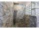 Stone-tiled shower with pebble floor and glass block window at 2425 W Woburn Ln, Phoenix, AZ 85085