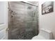 Walk-in shower with river rock tile floor, bench seating, updated shower head, and beautiful tile work at 2425 W Woburn Ln, Phoenix, AZ 85085
