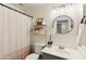 Well-lit bathroom featuring a single sink vanity, round mirror, and shower with decorative accents at 2768 W Jasper Butte Dr, San Tan Valley, AZ 85144