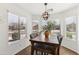 Bright dining area with large windows, a modern chandelier, and a wooden table with comfortable seating at 2768 W Jasper Butte Dr, San Tan Valley, AZ 85144