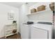 Clean and organized laundry room with modern washer and dryer units and shelving for storage at 2768 W Jasper Butte Dr, San Tan Valley, AZ 85144