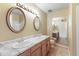 Bathroom with double sinks, marble countertops, wood cabinets, and decorative mirrors at 2935 W Kristal Way, Phoenix, AZ 85027