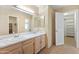 Bright bathroom featuring double sinks, a large mirror, and doorway access to a walk-in closet at 2935 W Kristal Way, Phoenix, AZ 85027