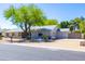 A well-maintained, single-story home featuring mature shade trees and desert landscaping at 2935 W Kristal Way, Phoenix, AZ 85027