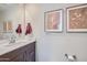 Tastefully decorated powder room with a vanity and framed artwork at 3330 S Lotus Ave, Mesa, AZ 85212