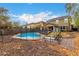 Backyard pool with a black metal safety fence and patio chairs, with two-story homes in the background at 3432 E Bartlett Dr, Gilbert, AZ 85234