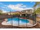 Backyard pool area surrounded by a safety fence with two-story homes in the background at 3432 E Bartlett Dr, Gilbert, AZ 85234