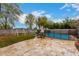 Backyard patio with a black metal safety fence surrounding the pool, and an umbrella and playground at 3432 E Bartlett Dr, Gilbert, AZ 85234