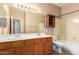 Full bathroom features double sinks, wood cabinet and bath/shower combo at 346 W Oxford Ln, Gilbert, AZ 85233