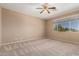 Bright bedroom featuring neutral carpeting, a ceiling fan, and a large window for natural light at 346 W Oxford Ln, Gilbert, AZ 85233