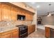 Charming kitchen showcasing oak cabinets, granite countertops, and black appliances at 346 W Oxford Ln, Gilbert, AZ 85233