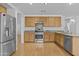 Open kitchen featuring wood cabinets, stainless steel appliances, granite countertops, and wood floors at 3478 E Park Ave, Gilbert, AZ 85234