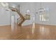 Spacious living room featuring wood floors, a staircase, large windows, and elegant modern chandelier at 3478 E Park Ave, Gilbert, AZ 85234