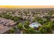 Beautiful aerial view of a neighborhood showcasing lush greenery, community pool, and stunning sunset colors at 3649 E Hutchins Ct, Gilbert, AZ 85295