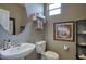 Cozy half bathroom with a pedestal sink, round mirror, and neutral color scheme at 3649 E Hutchins Ct, Gilbert, AZ 85295