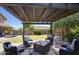 Backyard patio features a pergola covered seating area, with a dining table set and a lush green lawn at 3649 E Hutchins Ct, Gilbert, AZ 85295