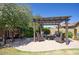 Relaxing patio featuring an outdoor seating area under a pergola next to lush greenery and a playhouse at 3649 E Hutchins Ct, Gilbert, AZ 85295