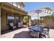 Outdoor patio area featuring a dining table, two chairs, and a grill, shaded by an umbrella at 3649 E Hutchins Ct, Gilbert, AZ 85295