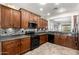 Kitchen featuring wooden cabinets, granite counters, tiled backsplash, and modern black appliances at 3810 S Star Canyon Dr, Gilbert, AZ 85297