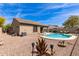 Backyard with desert landscaping, pool, and covered patio of single story home with brown exterior at 3810 S Star Canyon Dr, Gilbert, AZ 85297