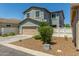 A two-story home with a tan garage door, low-upkeep landscaping, and a private driveway at 3850 E Robert St, Gilbert, AZ 85295