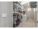 Well-organized laundry room with ample shelving, washer, dryer and light wood-look flooring at 3850 E Robert St, Gilbert, AZ 85295