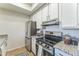 Galley kitchen featuring white cabinetry, stainless steel appliances, and granite countertops at 3930 W Monterey St # 136, Chandler, AZ 85226