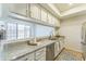 Bright kitchen with granite countertops, white cabinets, and stainless steel appliances with views to the living space at 3930 W Monterey St # 136, Chandler, AZ 85226