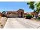 Lovely single-story house with a tile roof, an arched entryway, a desert front yard, and a long driveway leading to a garage at 3935 E Graphite Rd, San Tan Valley, AZ 85143