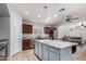 Open kitchen with cherry wood cabinetry, a granite-topped island, stainless steel appliances, and a view into the living area at 3935 E Graphite Rd, San Tan Valley, AZ 85143