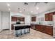Well-equipped kitchen with cherry wood cabinets, stainless appliances, tile flooring, and a blue island with bar stool seating at 3935 E Graphite Rd, San Tan Valley, AZ 85143