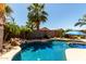 Refreshing pool surrounded by lush tropical landscaping, rock features and mature palm trees at 3935 E Graphite Rd, San Tan Valley, AZ 85143
