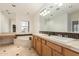 Bathroom featuring double sinks, large mirrors, a tub, and tile floors at 3935 E Rough Rider Rd # 1183, Phoenix, AZ 85050