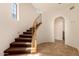 Bright staircase with wooden banister, decorative iron, and arched doorway at 3935 E Rough Rider Rd # 1183, Phoenix, AZ 85050
