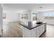 Open-concept kitchen with island featuring a sink, stainless steel dishwasher, and adjacent living space at 4064 E Ghost Flower Ln, San Tan Valley, AZ 85140