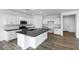 Bright kitchen featuring white cabinets, stainless steel appliances, and a large island with a black countertop at 4064 E Ghost Flower Ln, San Tan Valley, AZ 85140