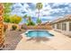 Backyard pool surrounded by rock landscaping, green foliage and a clear, blue sky at 4214 E Morrow Dr, Phoenix, AZ 85050