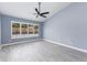 Bright bedroom with ceiling fan and ample natural light showcasing the gray wood-look floors at 4214 E Morrow Dr, Phoenix, AZ 85050