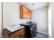 Spacious laundry room with updated washer and dryer, cabinet storage, and sink at 4214 E Morrow Dr, Phoenix, AZ 85050