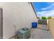View of side yard with air conditioner and trash bins along concrete wall under a bright blue, sunny sky at 4214 E Morrow Dr, Phoenix, AZ 85050