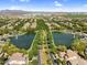 Stunning aerial view of dual community ponds with fountains, connected by a tree-lined street, enhancing the neighborhood's charm at 4355 E Cullumber St, Gilbert, AZ 85234